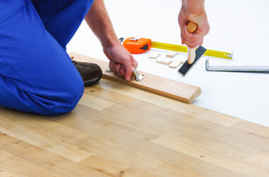 carpenter worker installing laminate flooring in the room